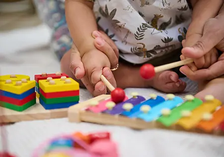 Infant playing with xylophone